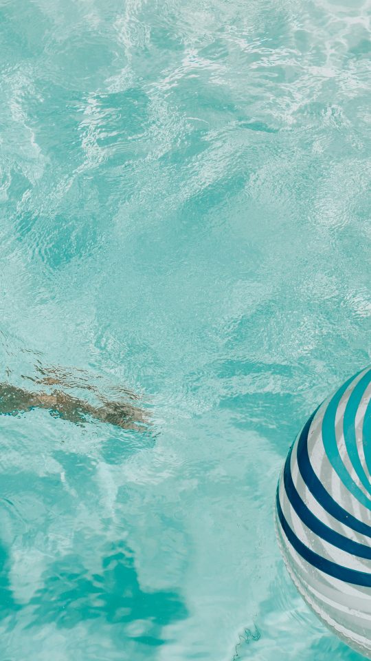 girl wearing swimsuit and swims in swimming pool